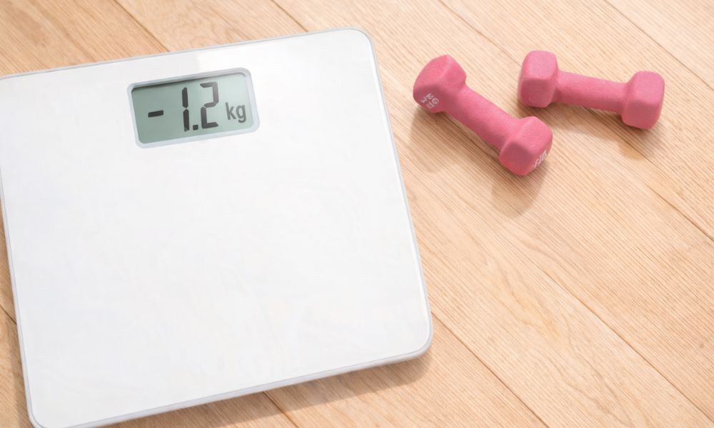 体重計とダンベルのダイエットイメージ。短期間の体重変化を表す写真