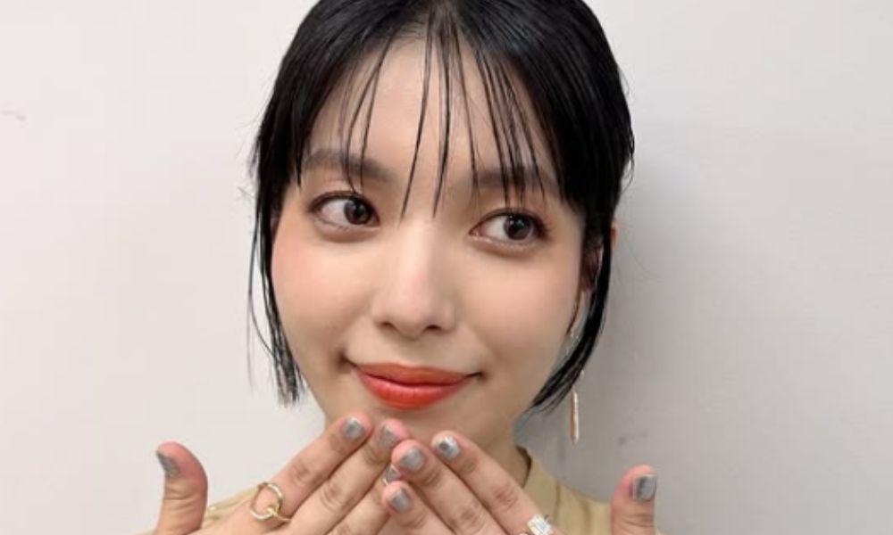 城南海がナチュラルメイクで微笑み、両手を口元に添えたアップショットのポートレート