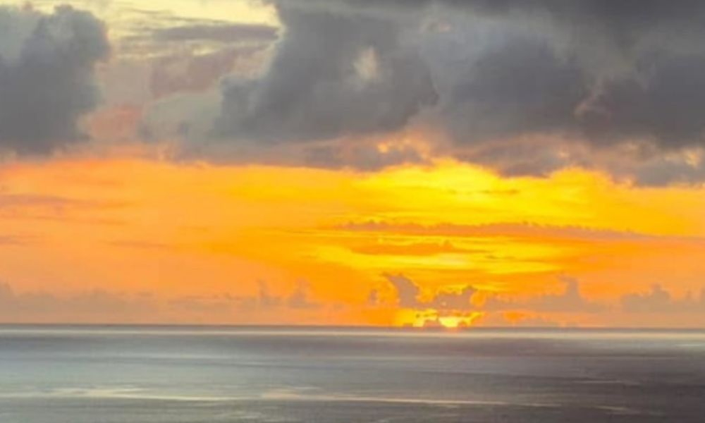 城南海の父が撮影した奄美の海に沈む夕日の写真、オレンジ色に染まる空と穏やかな水平線が広がる風景