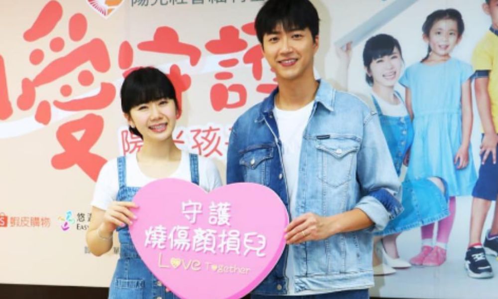 福原愛が陽光社会福祉基金会の記者会見に出席し、男性とともにハート型パネルを持って支援を呼びかける様子